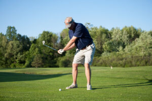 adult male golfer swinging club